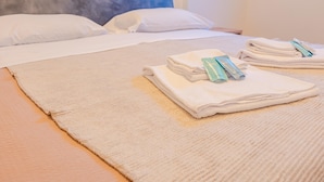A neatly made bed with white linens and two hair care products on top. - Residenza Del Porto - Italian Homing (Padenghe sul Garda)