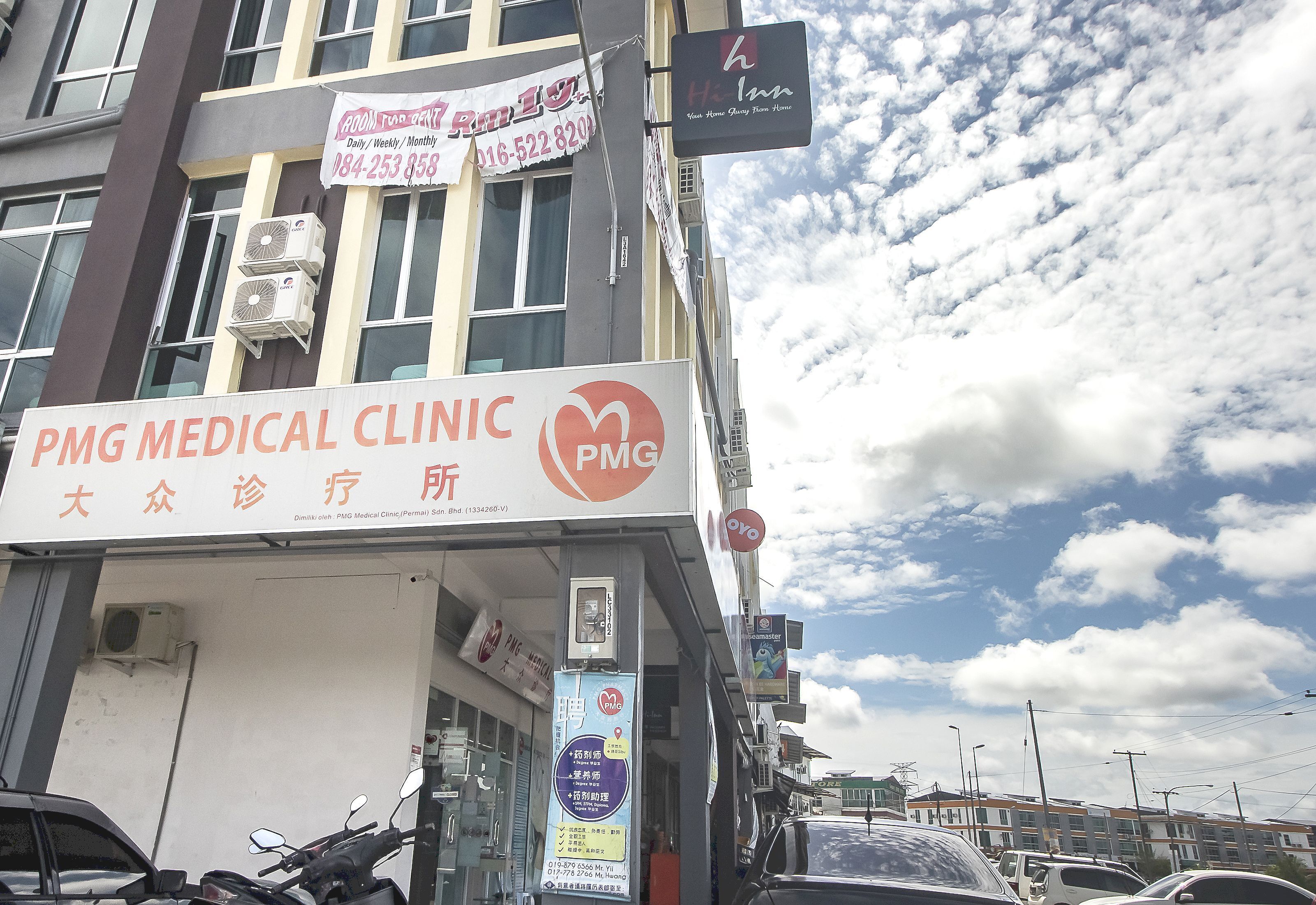 Un edifici amb un rètol per PMG Medical Clinic i un rètol per H Inn.