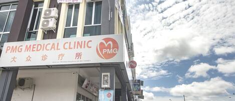 Un edifici amb un rètol per PMG Medical Clinic i un rètol per H Inn.