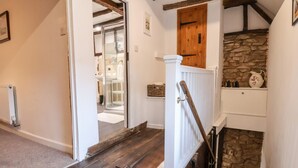 A wooden staircase with a stone wall and a wooden door. - The Brewhouse (Church Stretton)