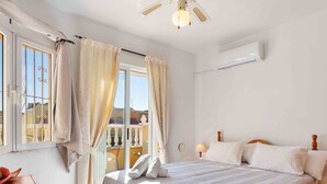 Ein Hotelzimmer mit einem Bett, einem Nachttisch, einer Lampe und einer Klimaanlage.