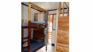 Una camera con un letto a castello, una scala in legno, un materasso blu e un pannello di legno a parete.
