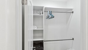 A bathroom with a towel rack, shelves, and a laundry basket. - La living bungalow with patio.  (Los Angeles)