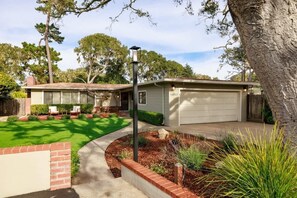 A residential property with a garage, a lawn, and a brick pathway.