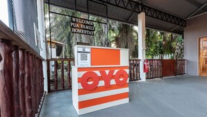 A reception desk with a sign reading "Welcome Pua Family Homestay" and a QR code. - OYO 90149 Pua Family Semporna (Semporna)