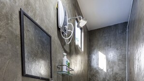 A bathroom with a large mirror, a wall-mounted sink, a toilet, and a showerhead. - OYO 90149 Pua Family Semporna (Semporna)