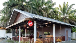 A restaurant with a covered patio, outdoor seating, and a sign reading "OYO." - OYO 90149 Pua Family Semporna (Semporna)