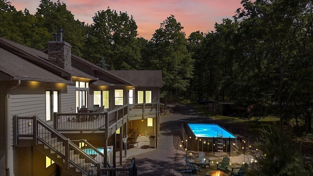 Kaksikerroksinen talo, jossa on parveke, uima-allas ja ulkotila oleskelua varten.