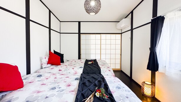 A room with a bed, a hanging light fixture, a window with a view, and a small table with a lamp. - Full Renovation/tamade Station 4 Min/2ldk/max 8 Persons (Osaka)