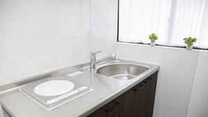 A modern kitchen with a stainless steel sink, wooden cabinets, and a window with potted plants. - Full Renovation/tamade Station 4 Min/2ldk/max 8 Persons (Osaka)
