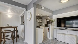 Een moderne keuken met een groot eiland, inbouwapparatuur en een flatscreen televisie.