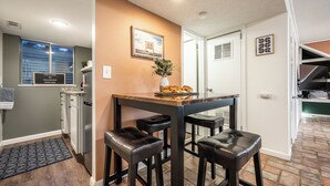 Una cocina moderna con comedor que incluye una mesa de madera y taburetes negros.
