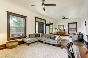 Una sala de estar amplia con un sofá seccional, un piano y una zona de comedor.