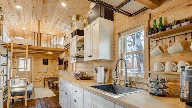 A compact kitchen with white cabinets, a sink, and a window.