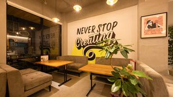 A modern interior with a motivational wall art, seating arrangements, and a visible café area.