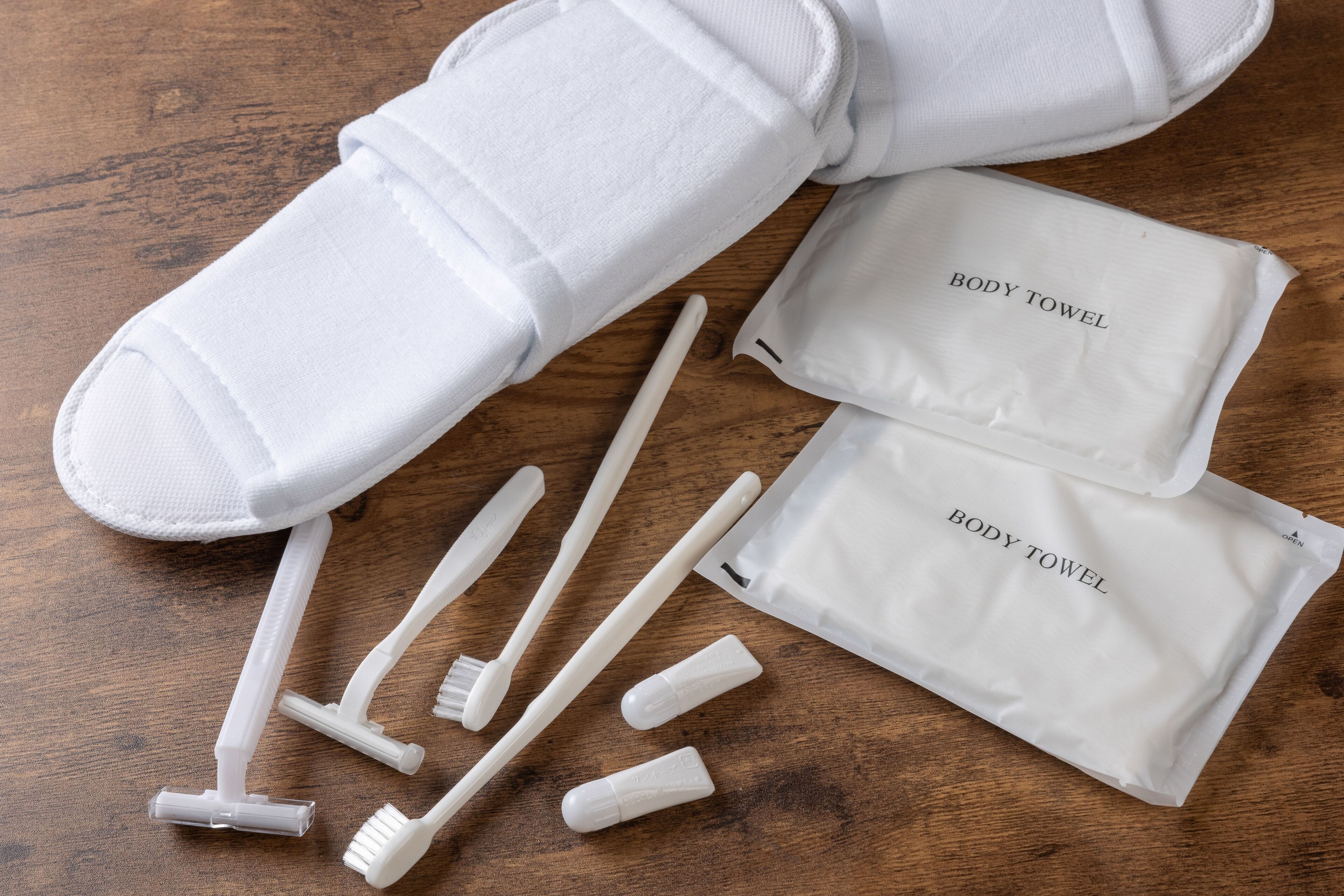 A white body towel set with a wooden surface.