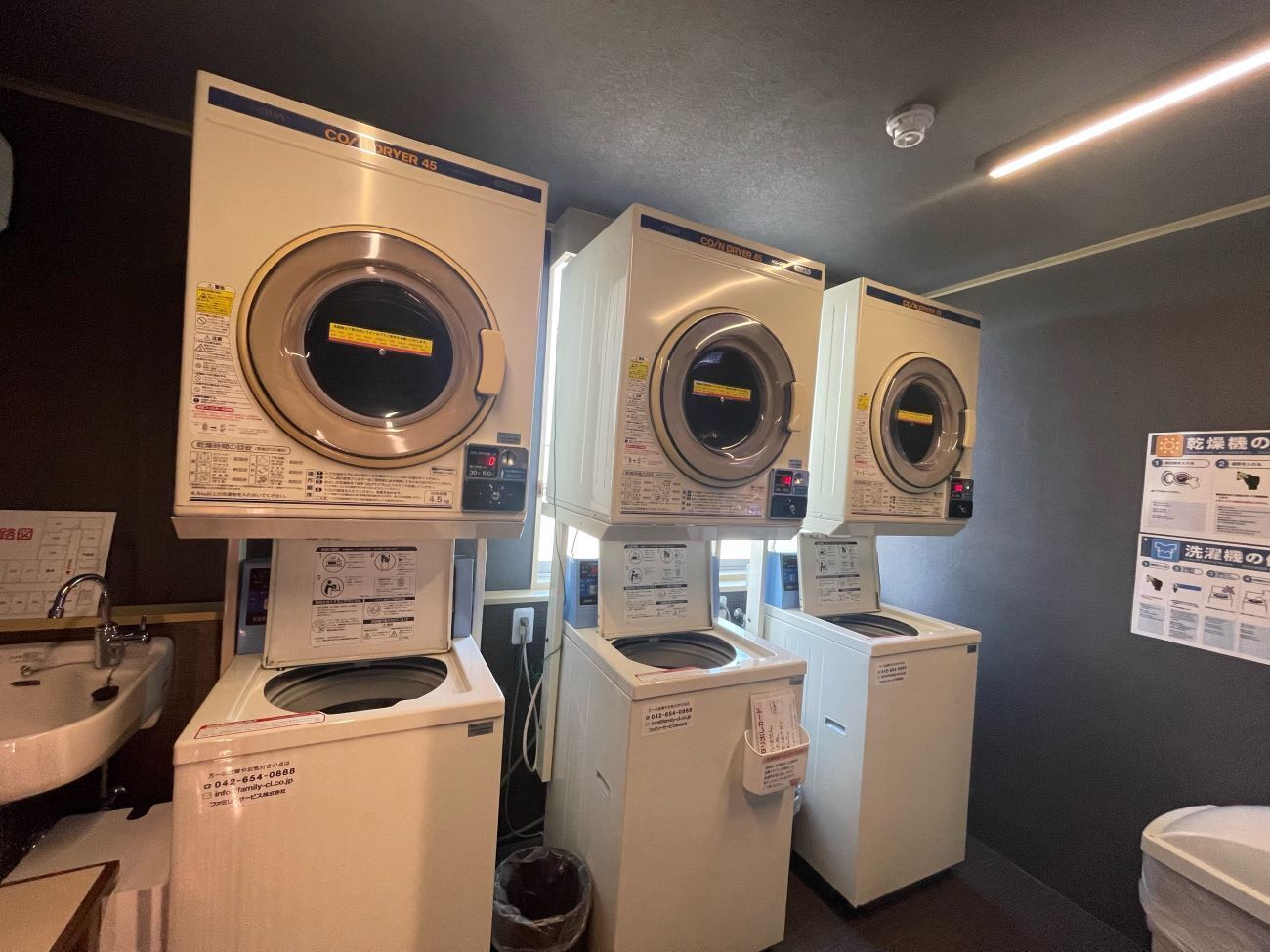 A laundry facility with multiple washing machines and a sink.