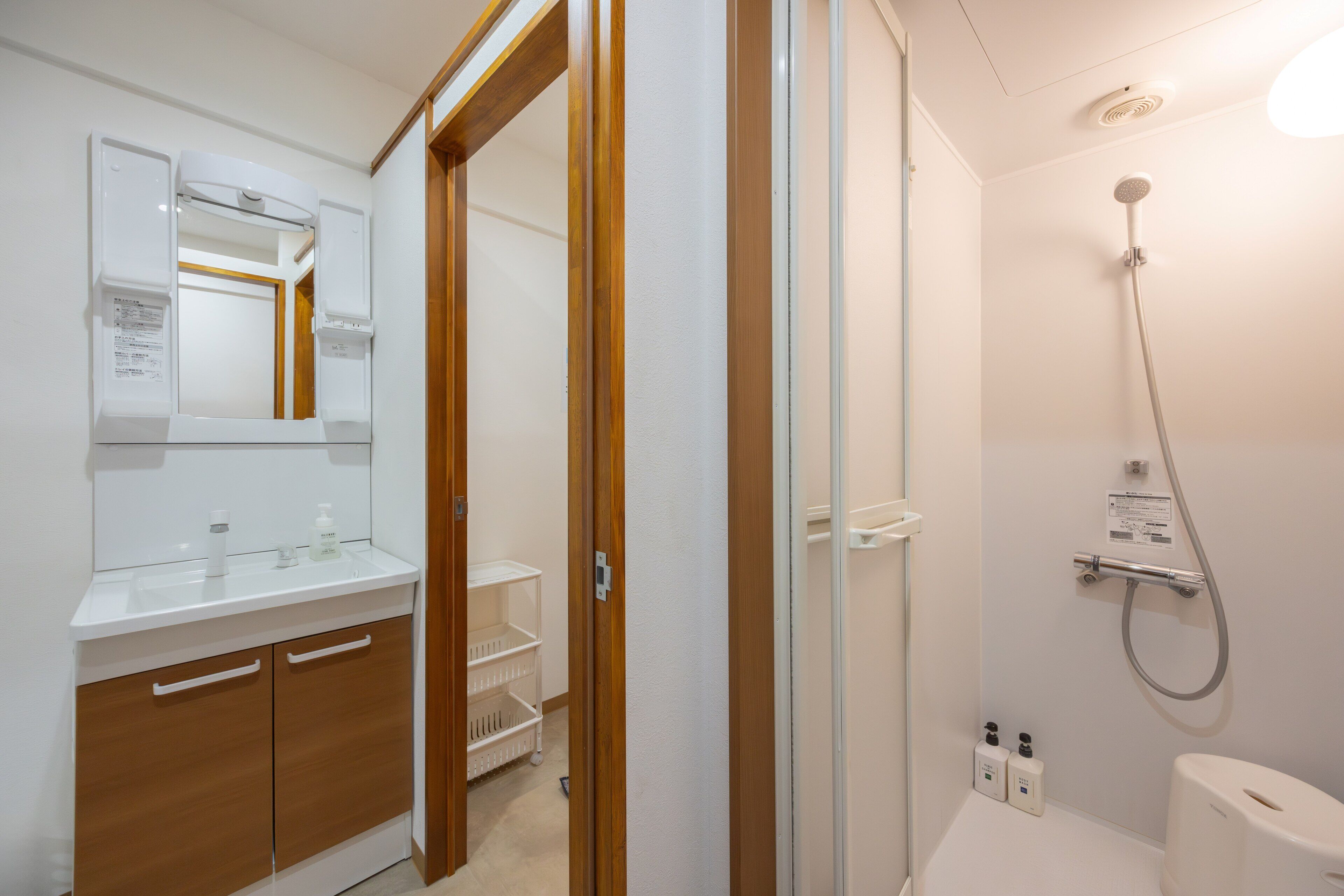 A bathroom with a shower, toilet, and a vanity with a mirror.