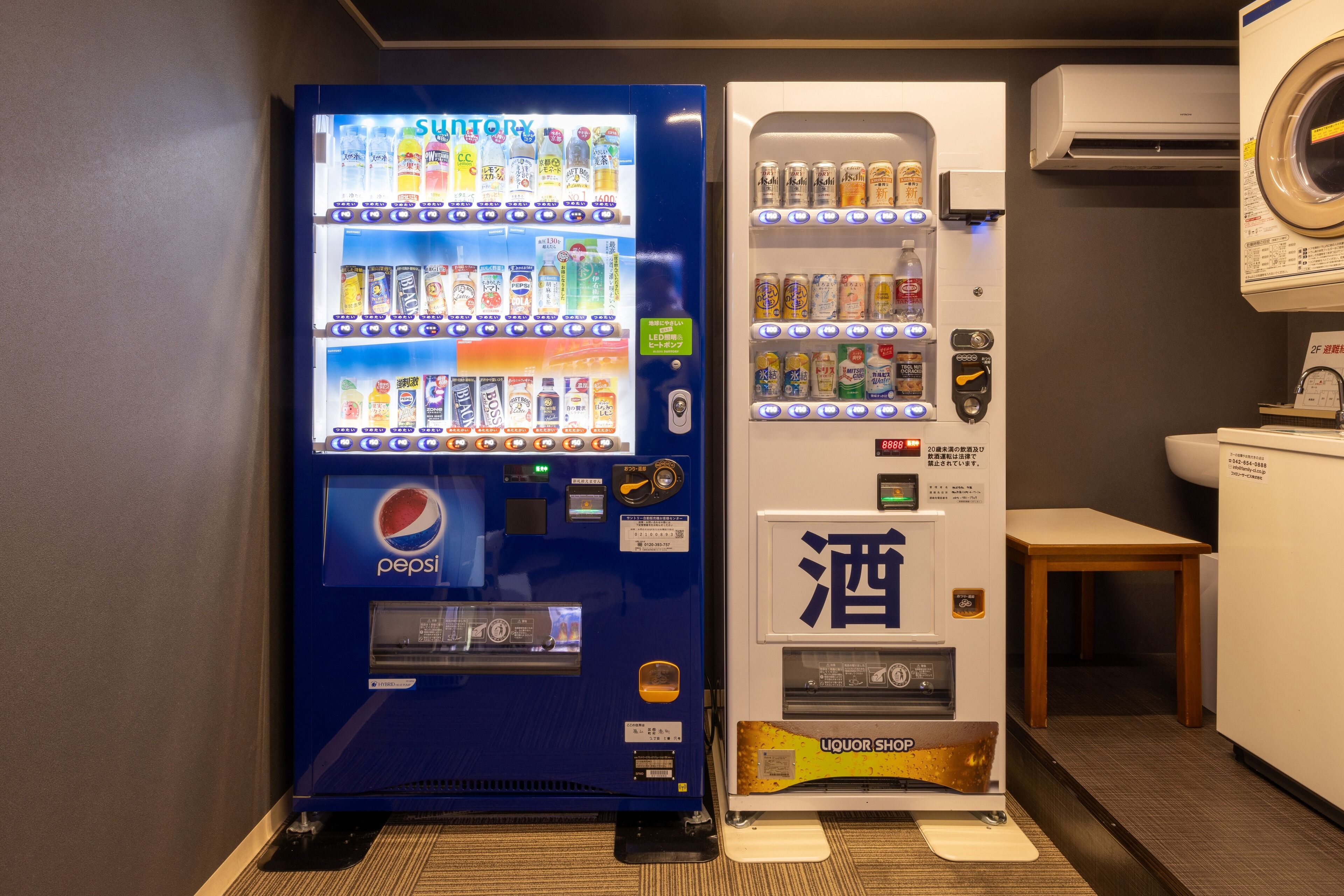 A vending machine with a Pepsi logo and a liquor shop.