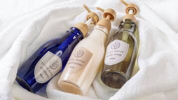 Three bottles of body care products on a white towel.