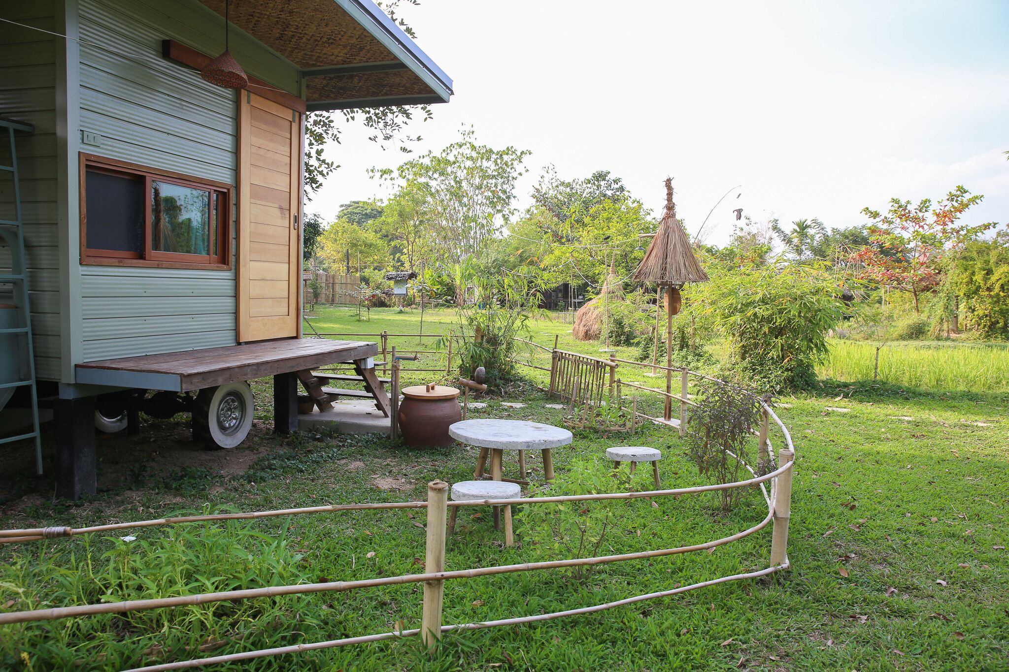 A rustic wooden building with a window, a table, and a bench outside.