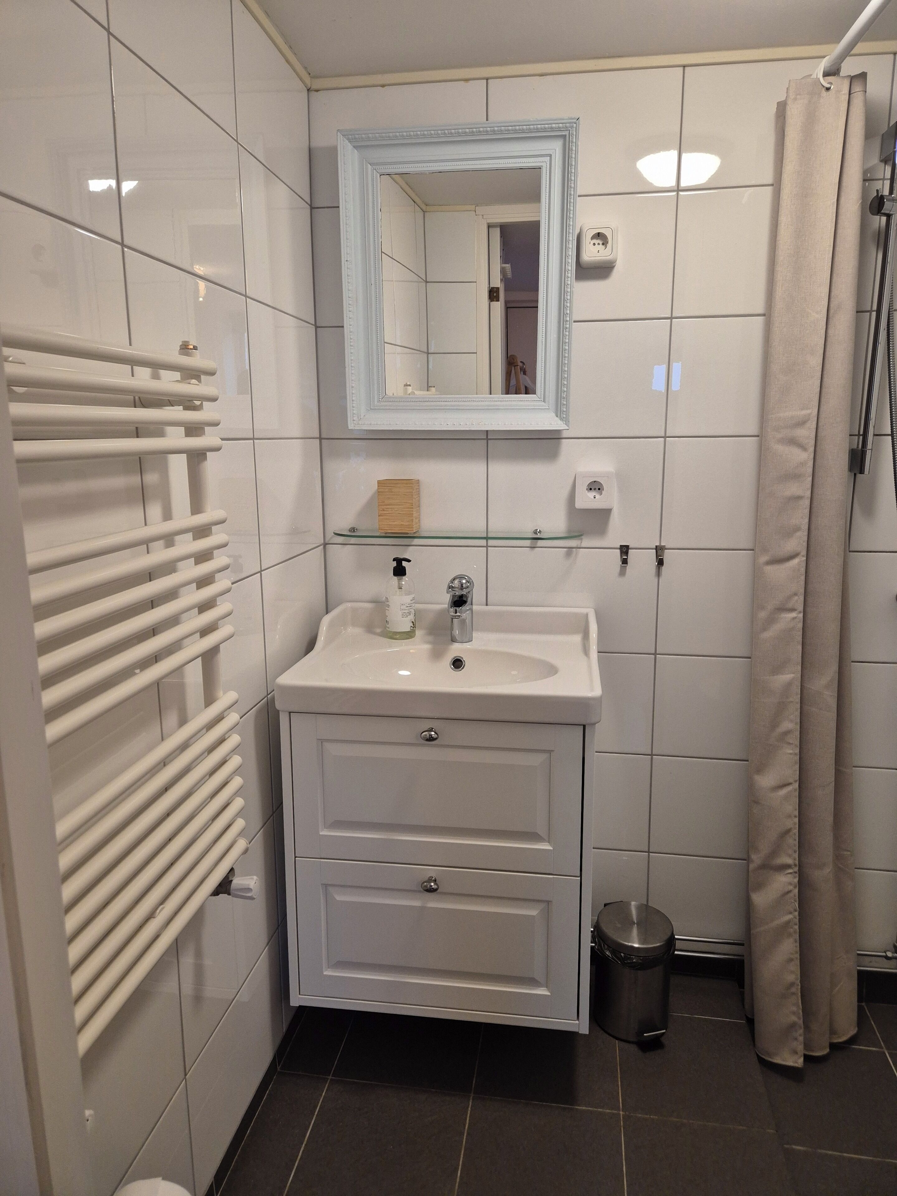A bathroom with a white sink, mirror, and towel rack.
