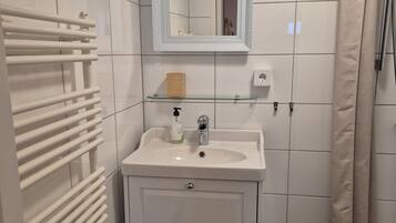 A bathroom with a white sink, mirror, and towel rack.
