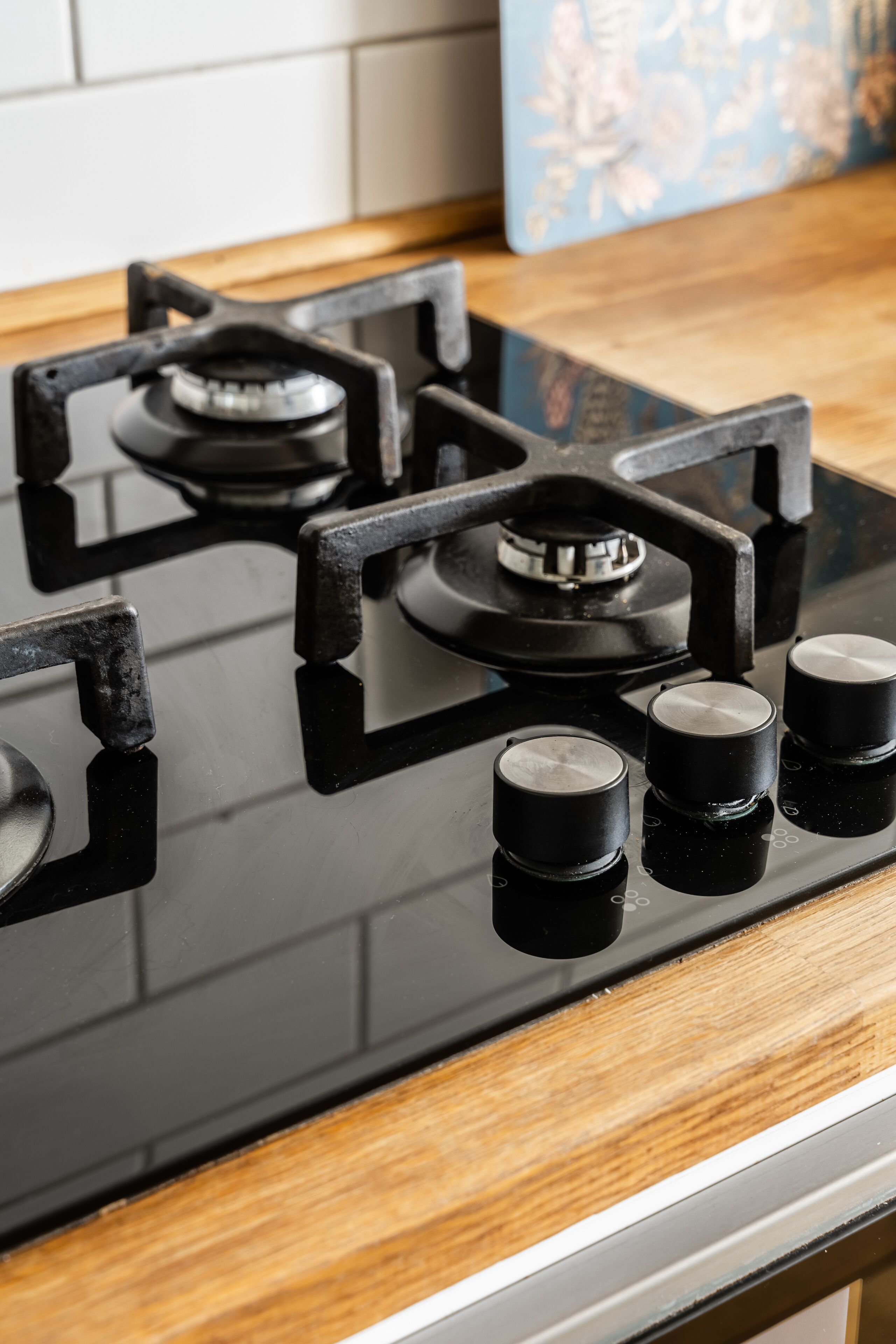 A kitchen with a black stovetop and wooden countertop.