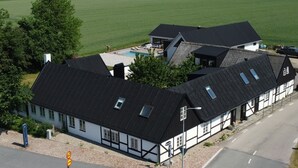 Ein traditionelles Gebäude mit Swimmingpool, umgeben von einem großen Grünland.