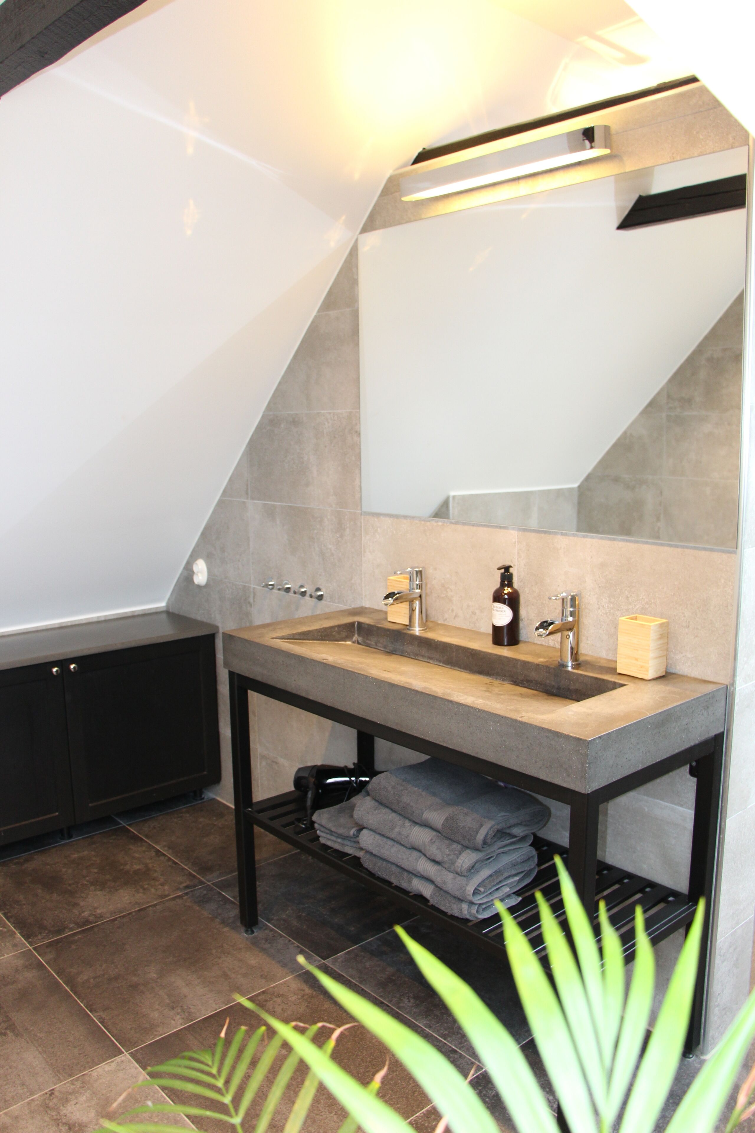 A modern bathroom with a large bathtub, a double sink, and a mirror above the sink.