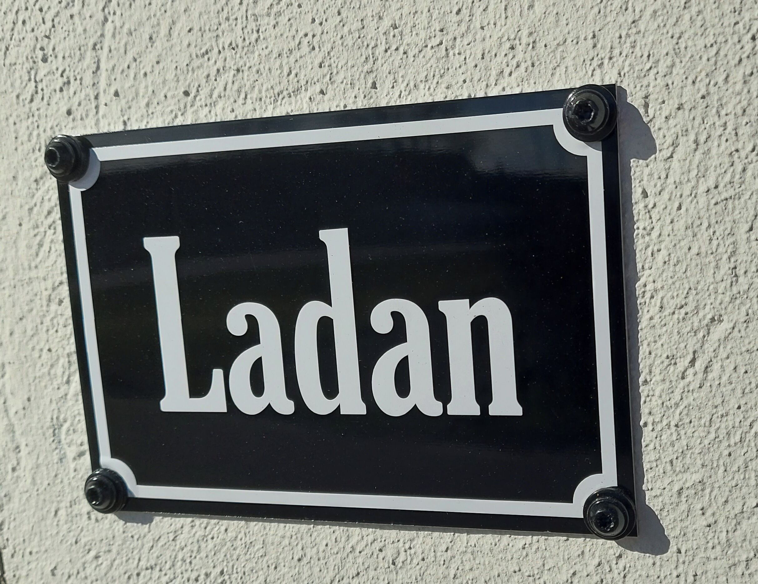 Un letrero blanco y negro con la palabra 'Ladan'.