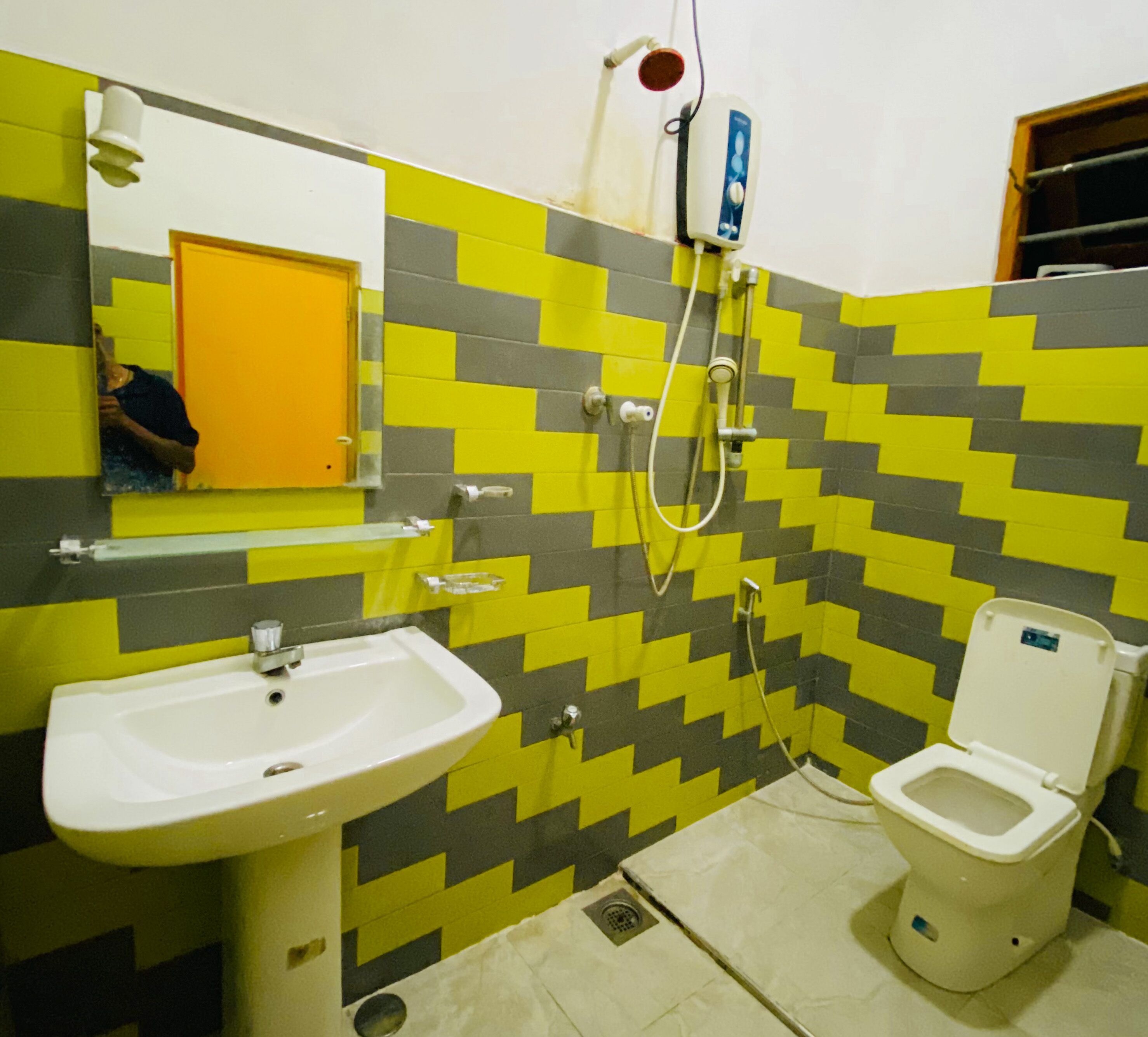 Un baño con lavamanos, inodoro y espejo.