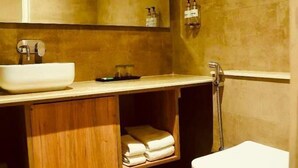 Un baño moderno con tocador de madera, un lavabo blanco y un inodoro.