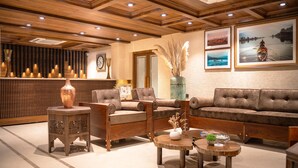 A modern interior with wooden furniture, a sofa, and a coffee table. - The Sarai (Srinagar)