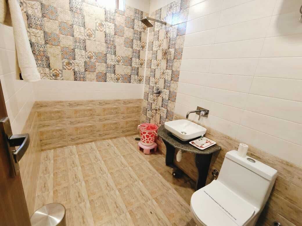 Egy fürdőszoba zuhanyzóval, WC-vel és mosdókagylóval.