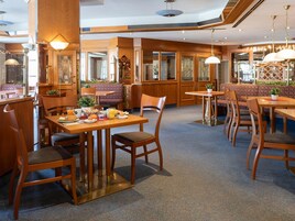 A restaurant with wooden furniture, a high ceiling, and a cozy atmosphere.