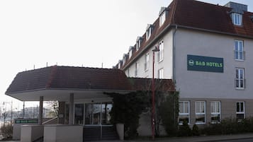 A B&B hotel with a covered entrance, a staircase leading to the entrance, and a clear sky.