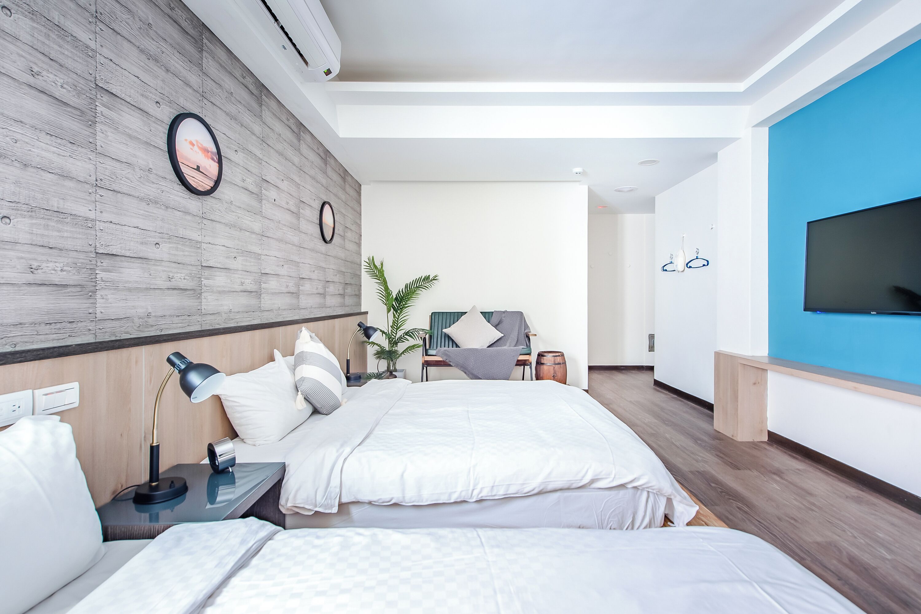 Une chambre d’hôtel moderne équipée de deux lits, d’une télévision, d’un bureau et d’une grande fenêtre.
