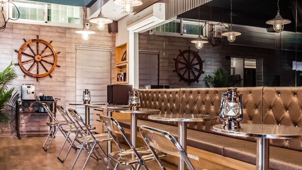 Un restaurant doté d’un long comptoir, de sièges confortables et d’un éclairage suspendu.