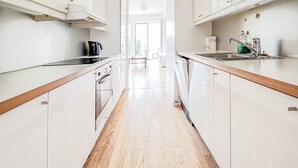 Une cuisine moderne avec des meubles blancs, des plans de travail en bois et un îlot central.