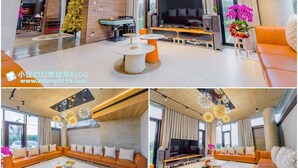 A modern living room with a large TV, comfortable seating, and decorative lighting. - 135 B&B (Dongshan)
