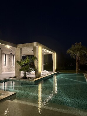 A modern outdoor pool area with a minimalist pool house and a palm tree. - 135 B&B (Dongshan)