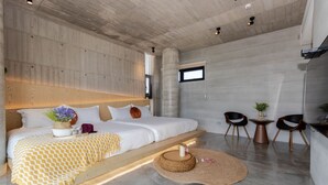 A modern bedroom with a large bed, bedside tables, and a small seating area with chairs and a table. - 135 B&B (Dongshan)