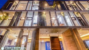A modern multi-story building with large windows and a wooden entrance. - 135 B&B (Dongshan)