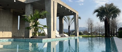 Una piscina al aire libre de temporada, sillones reclinables de piscina