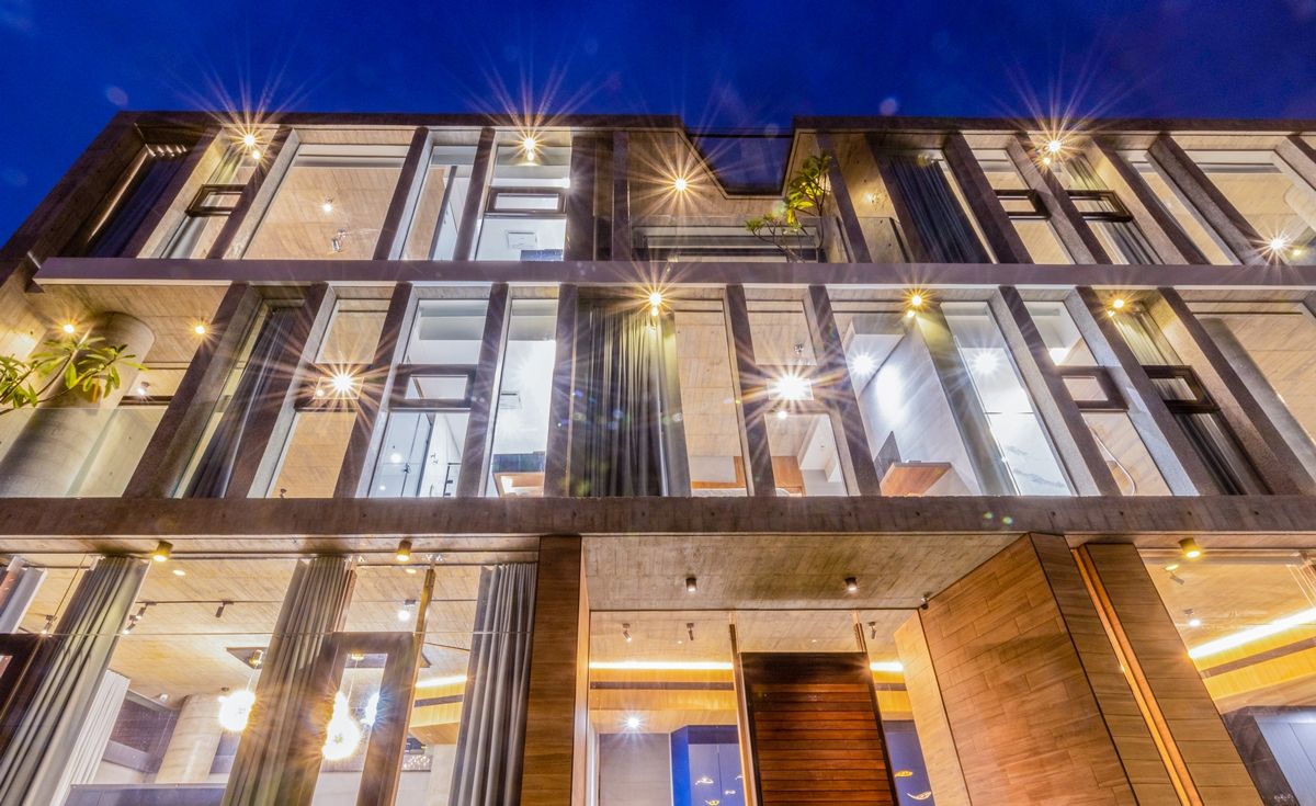 A modern multi-story building with large windows and a wooden entrance.