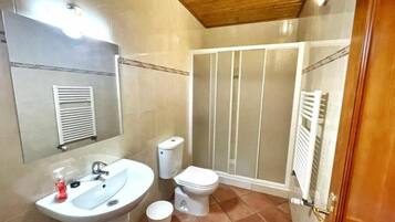 Un baño con lavamanos, inodoro y ducha.
