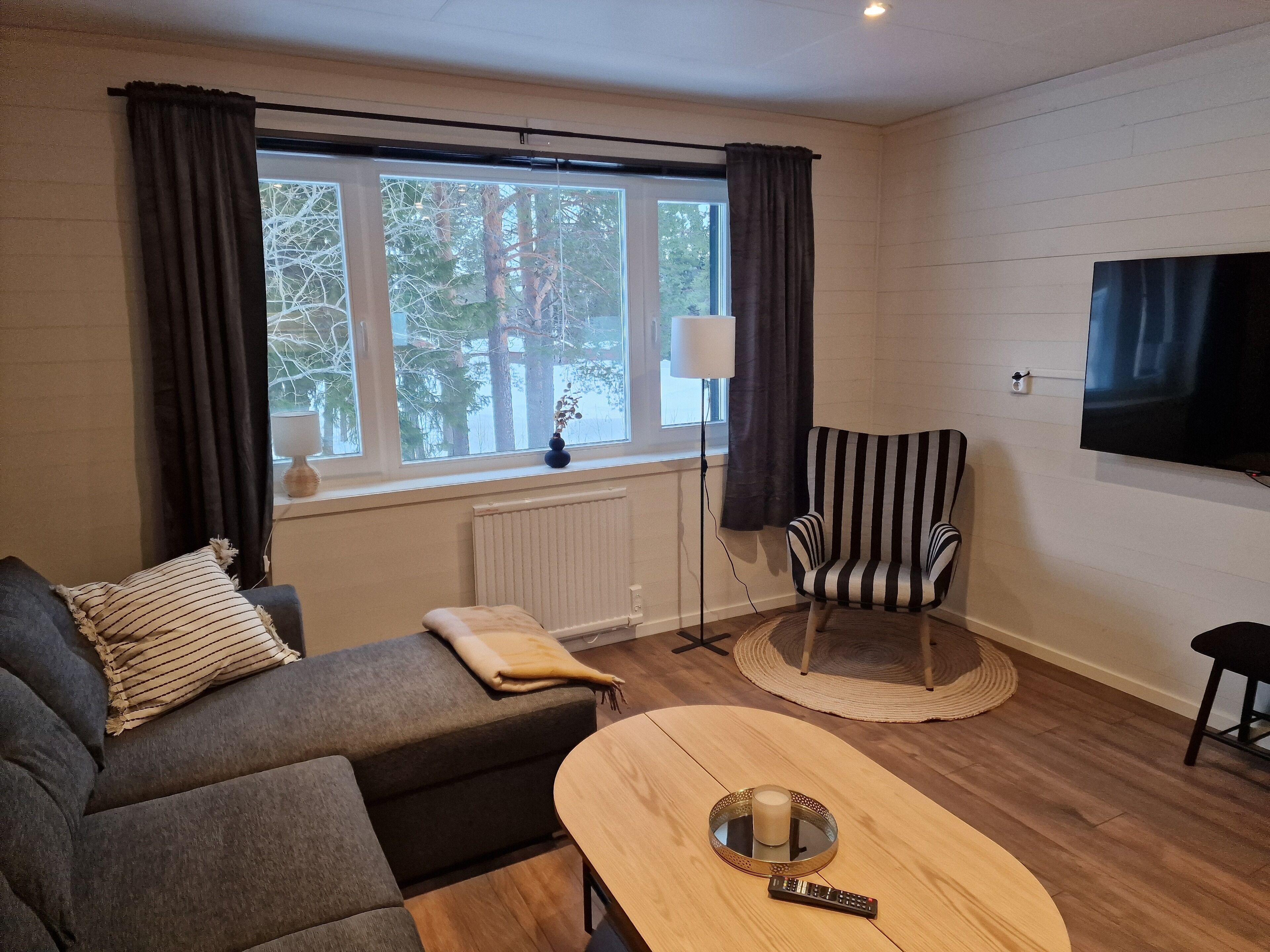 A modern living room with a sofa, armchair, and a coffee table.