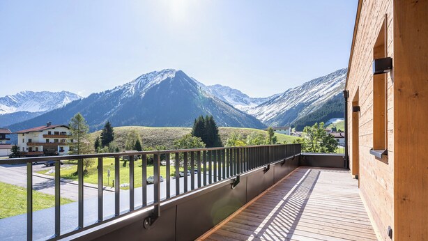 A balcony with a view of snow-capped mountains, a wooden deck, and a metal railing. - TOP 5 - Luxuriöses Apartment in der Tiroler Zugspitzarena (Berwang)