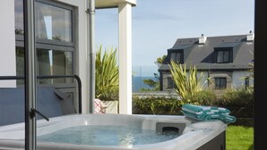 Un jacuzzi avec vue sur la mer et des maisons en arrière-plan.